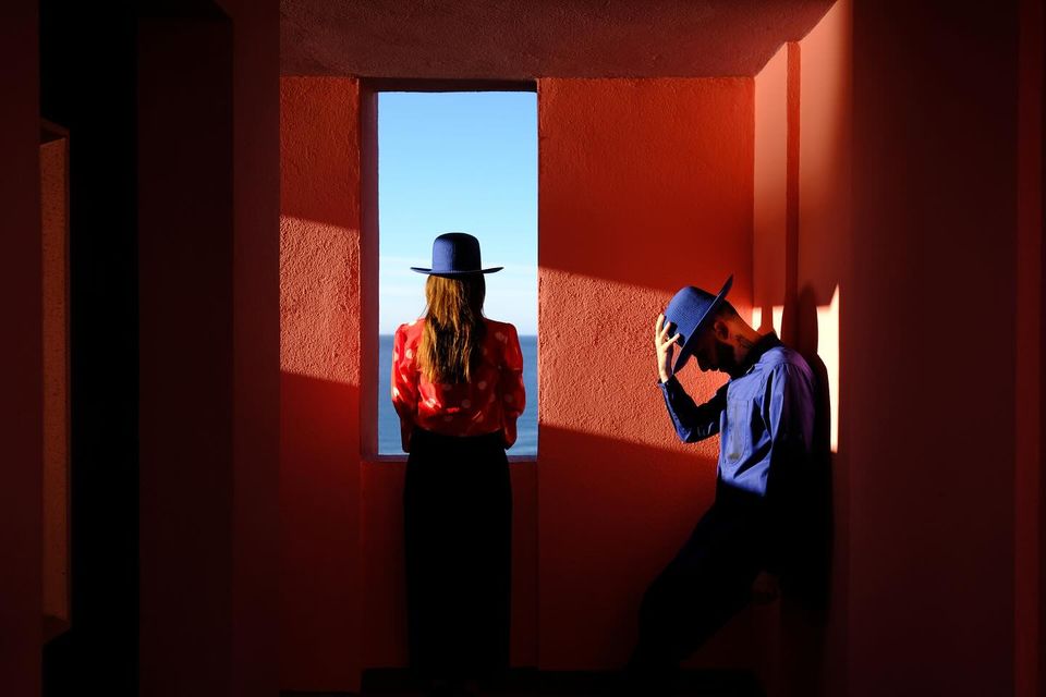 Couple framed in red terracotta window at La Muralla Roja