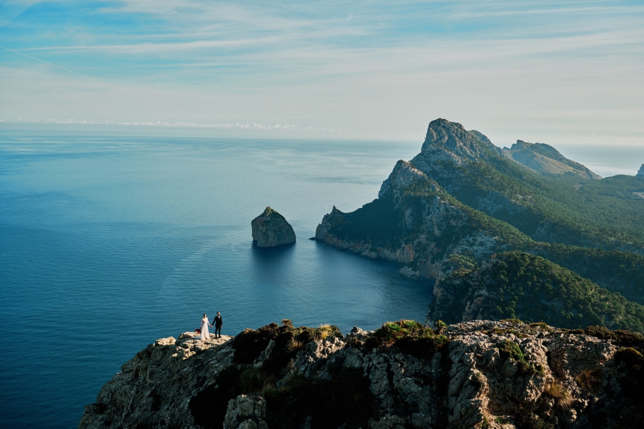 Wedding couple being photographed on a cliff in Mallorca