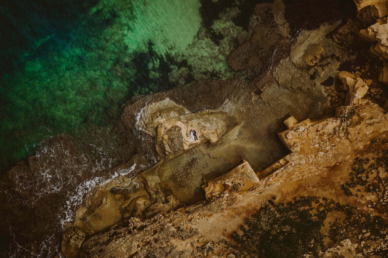 Wedding couple being photographed from above using a drone on a beach in Mallorca