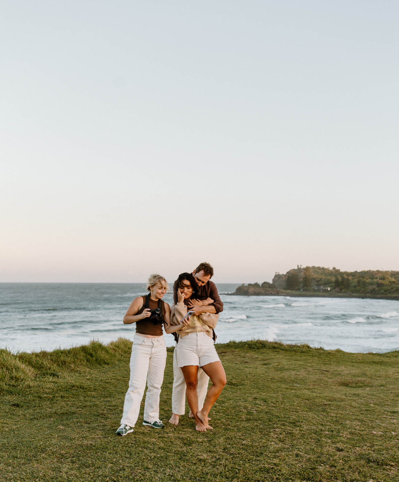 Two people standing close and quiet together on a coastal headland